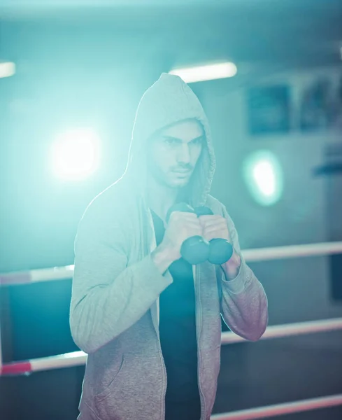 ボクシングのコンセプト ボクシングリングでダンベルとボクシング運動中のボクサーの男 — ストック写真