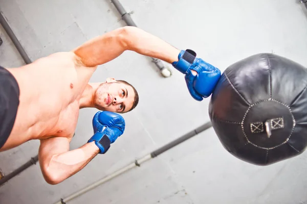 Bonito Homem Esportes Boxeador Treina Socos Mão Com Saco Perfuração — Fotografia de Stock