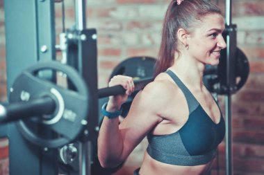 Smiley portre gülümseyen atletik kadın Smith makinede halter ile egzersiz