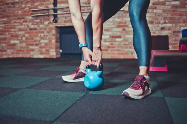 Spor salonunda kettlebell tutan sporcu kadın. Egzersiz konsepti