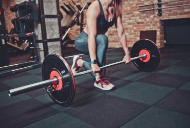 Yakın çekim kadın spor salonunda yerden ağır bir halter alır. Egzersiz concep