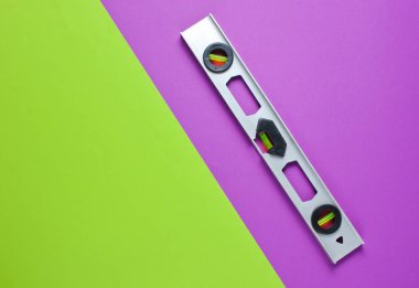 Yeşil mor arka planda inşaat seviyesi. Minimalizm