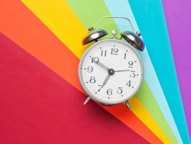 Renkli gökkuşağı arka planda retro çalar saat. Üst te. Minimalizm.