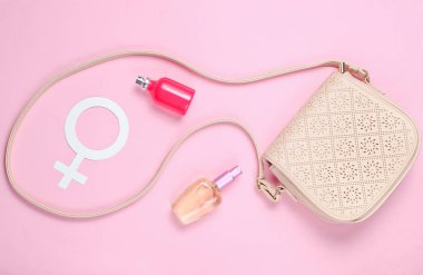Deri çanta, kadınların cinsiyet sembolü, pastel pembe arka plan üzerinde parfüm şişeleri. Üstte görüntü