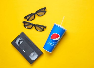 Ukrayna, Odessa-7 Ocak 2019: saman, video kaseti, sarı arka planda 3D gözlük ile Pepsi kağıt fincan. Pop kültür 80s, retro tarzı. Üst görünüm. Minimalizm