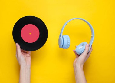 Kadınların elleri kulaklık ve vinil rektör takar.