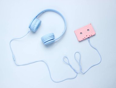 Gri arka plan da ses kasetinde kablolu mavi kulaklıklar. Üstte görüntü