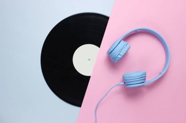 Retro 70'ler. Müzik aşığı. Kulaklıklar, pembe gri arka plan lp kaydı. Düz yatıyordu. Üstte görüntü.