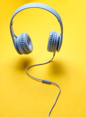 Sarı arka plan üzerinde kablo ile 3d surround fotoğraf modern mavi kulaklıklar.