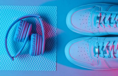 Spor ayakkabılar ve kulaklıklar. Retro dalga, neon ışık, morötesi. Üst görünüm, minimalizm