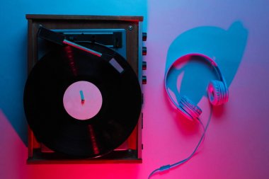 İp kaydı olan bir vinil çalar. Retro dalga, neon ışık, morötesi. Gece kulübü. Üst görünüm, minimalizm