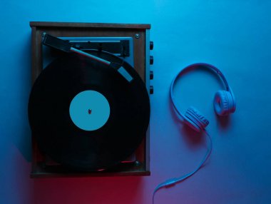 İp kaydı olan bir vinil çalar. Retro dalga, neon ışık, morötesi. Gece kulübü. Üst görünüm, minimalizm
