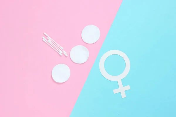 Products for feminine hygiene, self-care and health, female gender symbol on pastel background. Ear sticks, pads. Top view