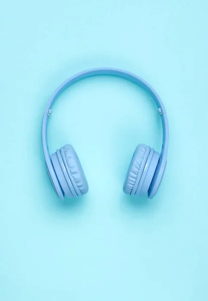 Modern Blue Wireless Over-Ear Headphones on blue pastel background. Minimalism. Top view