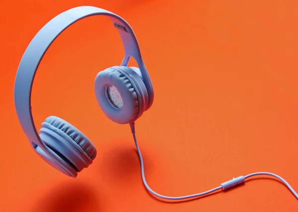 3Dサラウンド写真オレンジの背景にケーブル付き現代的な青のヘッドフォン — ストック写真