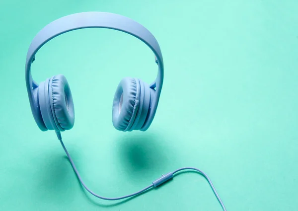 Foto Envolvente Auriculares Azules Modernos Con Cable Sobre Fondo Verde —  Fotos de Stock