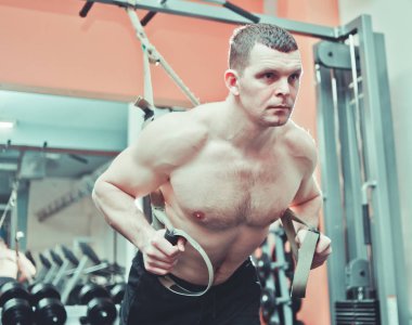 Güçlü bir adam spor salonunda şınav çekerek şınav çeker. 