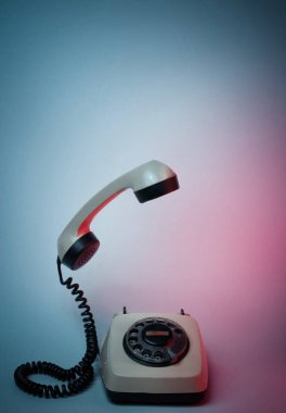 Yükselen telefon saplı eski usul döner telefon, neon ışık, 80 'ler.