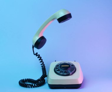 Yükselen telefon saplı eski usul döner telefon, neon ışık, 80 'ler.