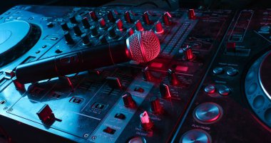 Gece kulübü, gece hayatı konsepti. Disko. DJ kumandasındaki mikrofon. Neon kırmızı mavi ışık