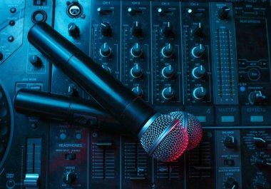 Gece kulübü, gece hayatı konsepti. Disko. DJ kumandasında iki mikrofon. Neon kırmızı mavi ışık