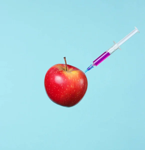 Zmodyfikowane Genetycznie Czerwone Jabłko Strzykawkami Niebieskim Tle Strzykawka Medyczna Wstrzykiwanie — Zdjęcie stockowe