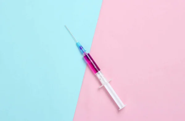 ミニマリズム医療概念 予防接種 青いピンクのパステルの背景に紫色の液体を持つ注射器 — ストック写真