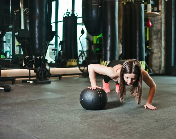Woman Doing Push Ups Whith Medicine Ball Dark Gym — Stock Photo, Image