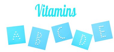 Vitaminler A, B, C, D, E. Mavi arka plandaki beyaz haplardan A, B, C, D, E harfleri. Asgari tıbbi konsept. Üst görünüm.