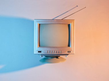 Retro dalga, 80 'ler. Antenli, neon ışıklı eski bir televizyon. Üst görünüm, minimalizm