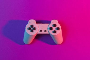 Retro gempad neon pembe ışıkta. Minimalizm, üst görünüm