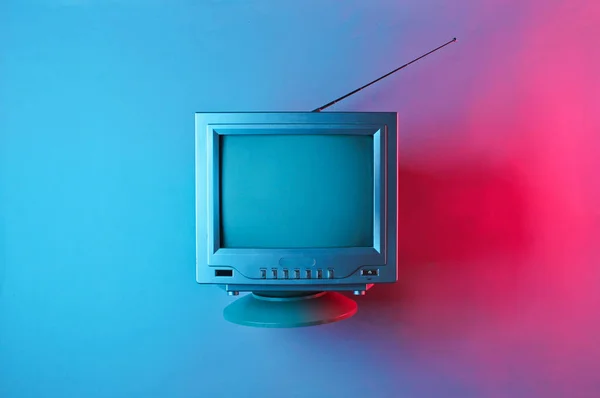 Retro dalga, 80 'ler. Antenli, neon ışıklı eski bir televizyon. Üst görünüm, minimalizm