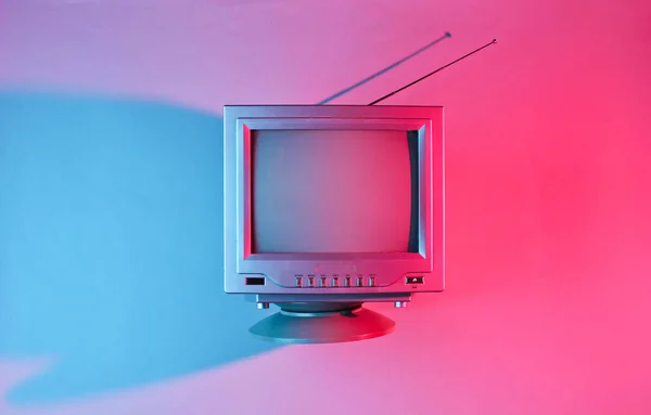 Retro dalga, 80 'ler. Antenli, neon ışıklı eski bir televizyon. Üst görünüm, minimalizm