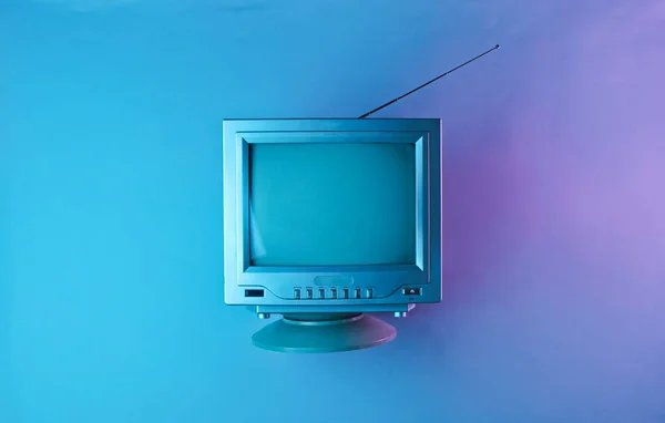Retro dalga, 80 'ler. Holografik ışıkta antenli eski bir televizyon. Üst görünüm, minimalizm