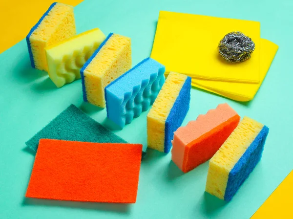 Mavi arka planda ev ve banyo temizleme seti. Süngerler, aşındırıcılar.