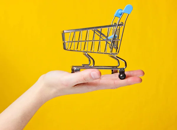 Mini Toy Metal Shopping Trolley Female Hand Yellow Background Delivery — Stock Photo, Image