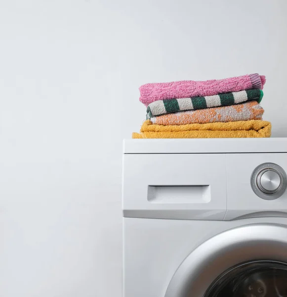 洗衣机上堆满了毛巾 白人背景 — 图库照片