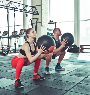 çift fonksiyonel eğitim. Sportif erkek ve formda kadın spor salonunda kettlebell ile egzersiz yapıyor.