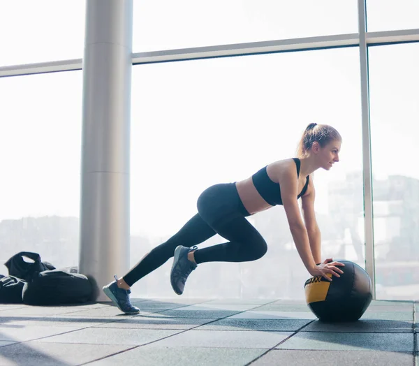 Спортивная Привлекательная Женщина Делает Упражнения Поднимая Ногу Опираясь Медицинский Мяч — стоковое фото