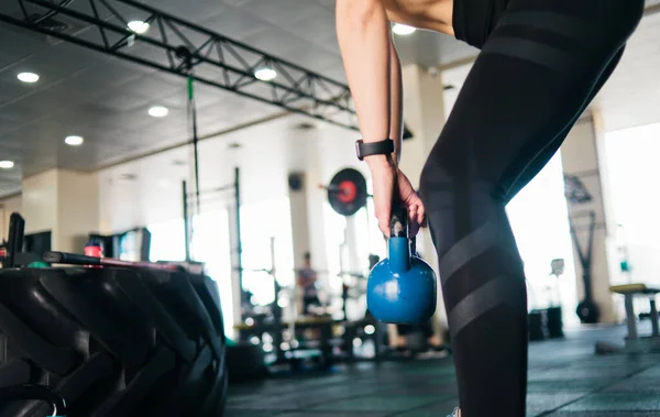 Functional training with a kettlebell. Closeup woman doing exercise with kettlebell in gym