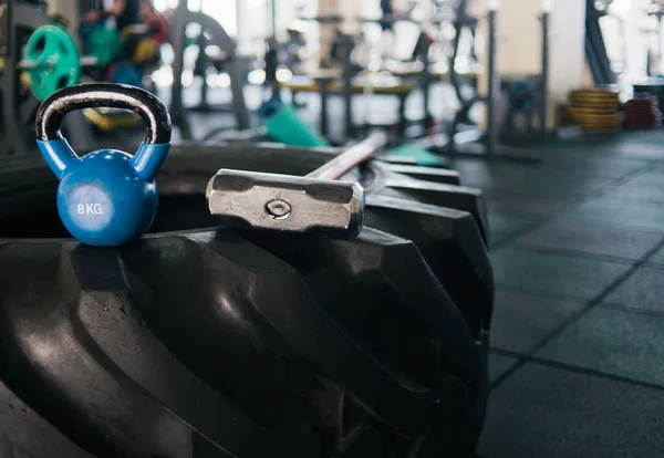 Equipment for functional training. Large rubber wheel, hammer, kettlebell closeup in the gym. Cross training