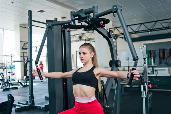 Νεαρή Γυναίκα Στα Αθλητικά Κάνει Άσκηση Μηχάνημα Γυμναστικής Στο Γυμναστήριο — Φωτογραφία Αρχείου