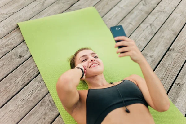 Jonge Vrolijke Sportvrouw Sportkleding Luistert Naar Muziek Houdt Smartphone Zijn — Stockfoto