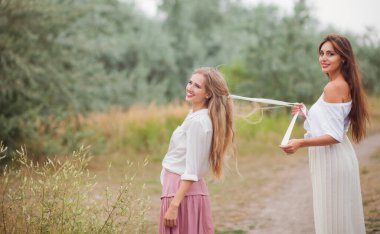 İki neşeli en iyi kız arkadaş eski tarz kıyafetler giyip yaz günü yola çıkıyorlar.