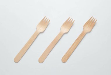 Beyaz arka planda bir sürü çevre dostu ahşap çatal var. Minimalist eko kavramı