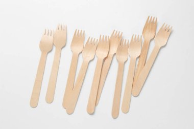 Beyaz arka planda bir sürü çevre dostu ahşap çatal var. Minimalist eko kavramı