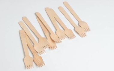 Beyaz arka planda bir sürü çevre dostu ahşap çatal var. Minimalist eko kavramı