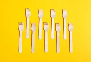 Sarı arka planda bir sürü çevre dostu ahşap çatal. Minimalist eko kavramı. Pop sanat