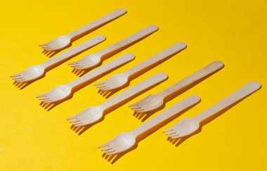 Sarı arka planda bir sürü çevre dostu ahşap çatal. Minimalist eko kavramı. Pop sanat