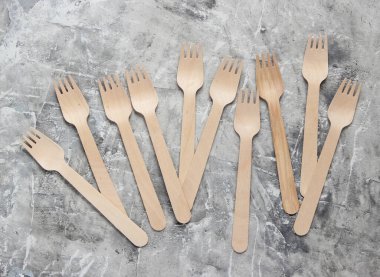 Gri beton arka planda çevre dostu bir sürü çatal var..